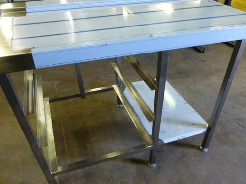 1100mm exit table with fully anti drip tray slide, below are runners for empty baskets and a small undershelf.